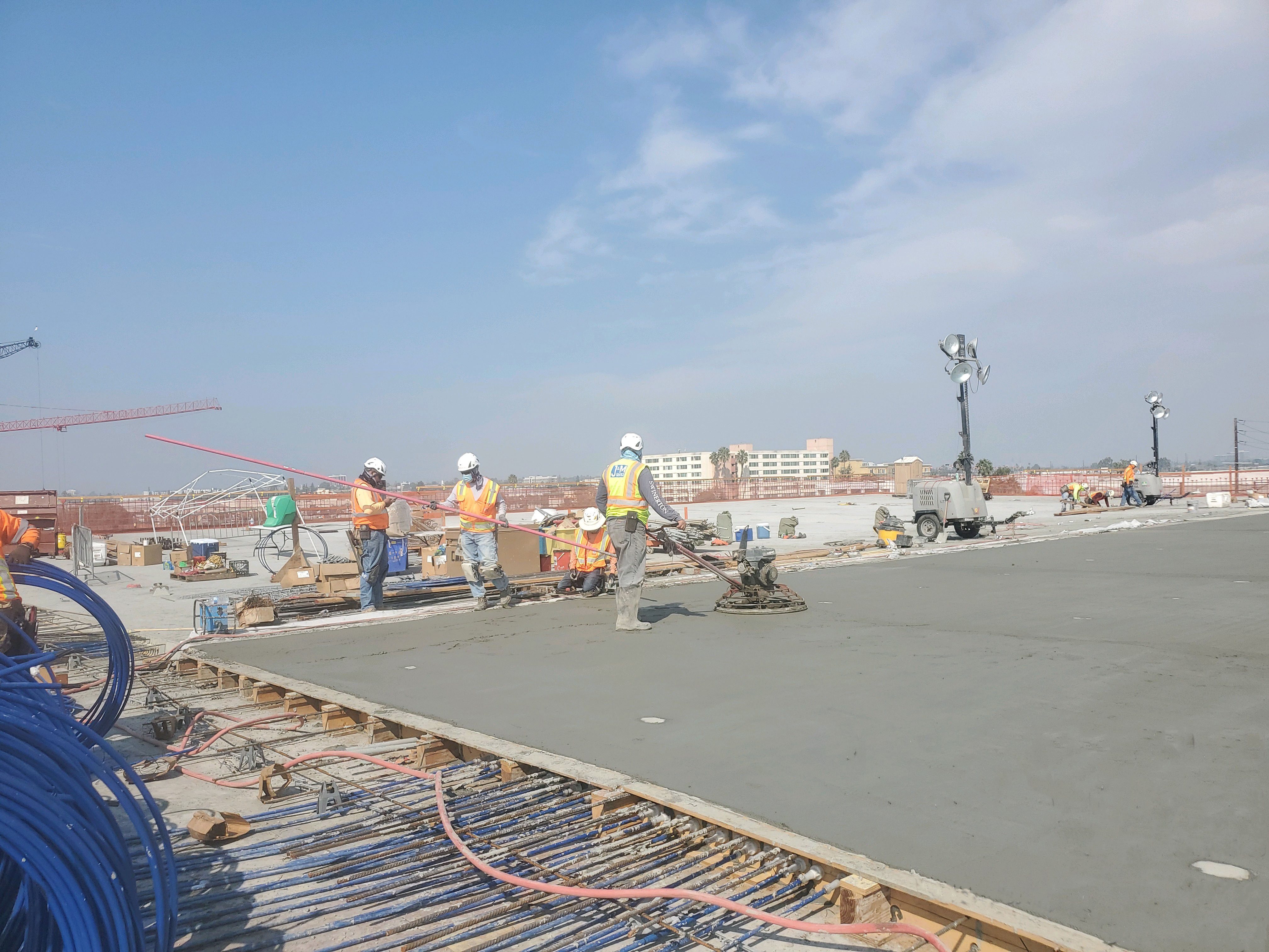 Workers are completing the deck final finishing post pour on the roof level of the Consolidated Rent-A-Car Facility Quick Turn Around (QTA) Building.